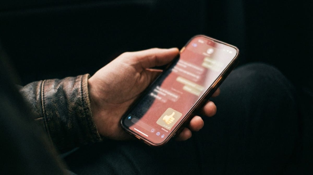 Close-up of person holding smartphone and texting conversation on messaging app
