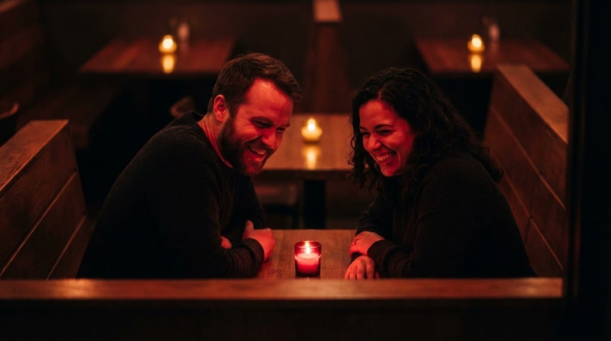 Couple laughing together during candlelight date at restaurant