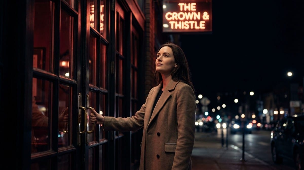 Woman opening the door of a bar at night under a glowing sign, standing on a city street with warm red lighting and traffic lights in the background.